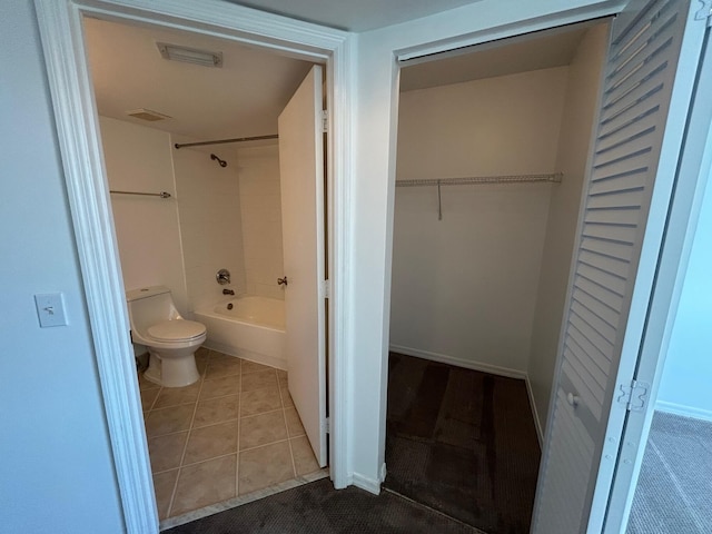 bathroom featuring tile patterned flooring, bathing tub / shower combination, and toilet