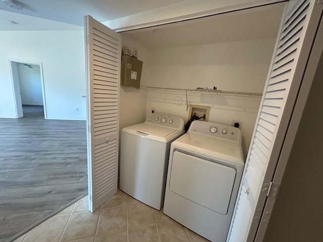 laundry area featuring washer and dryer, light tile patterned floors, and electric panel