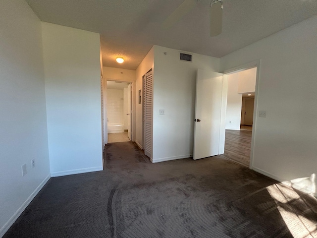 empty room with dark carpet and ceiling fan