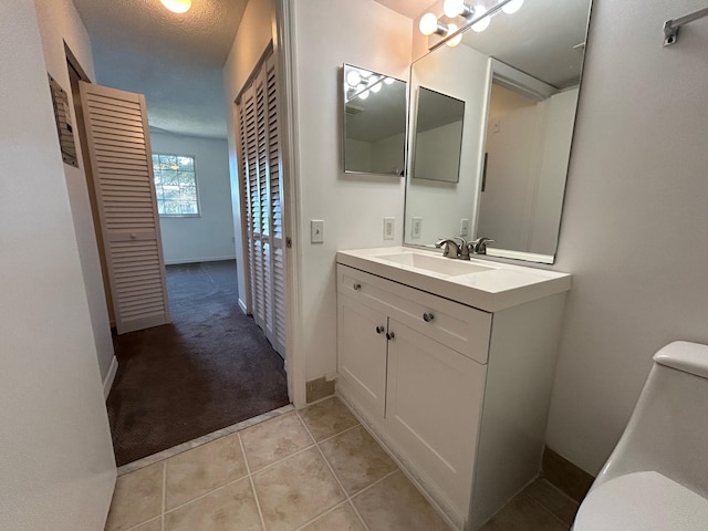 bathroom with vanity, tile patterned floors, a textured ceiling, and toilet