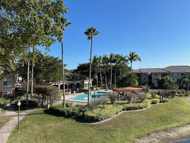 view of swimming pool with a yard and a pergola