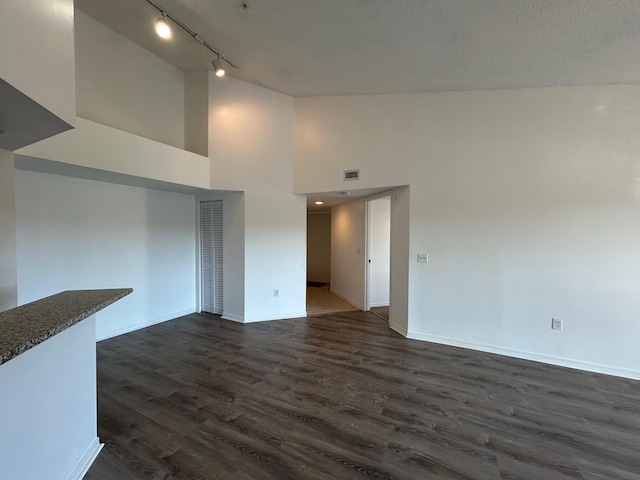 unfurnished living room featuring dark hardwood / wood-style flooring and high vaulted ceiling