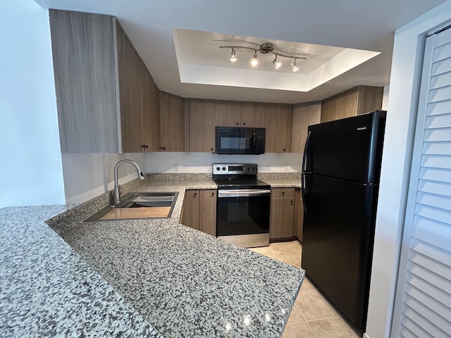 kitchen featuring sink, black appliances, kitchen peninsula, light tile patterned flooring, and a raised ceiling