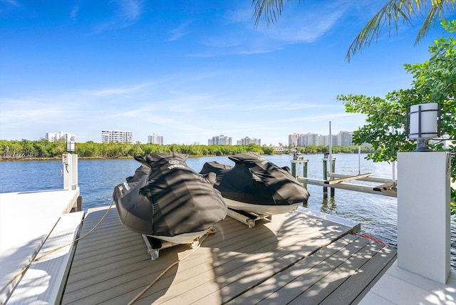 dock area with a water view, boat lift, and a view of city