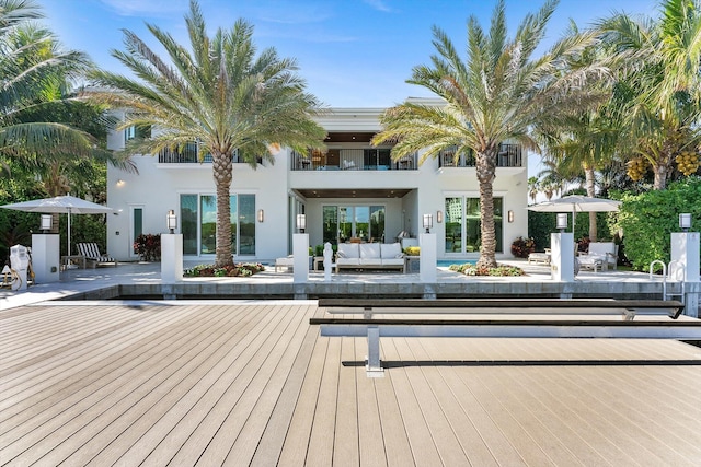 rear view of house with stucco siding and outdoor lounge area