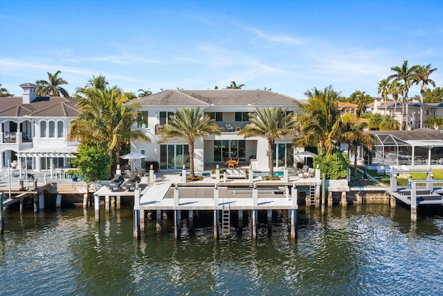 rear view of house with a water view and a balcony