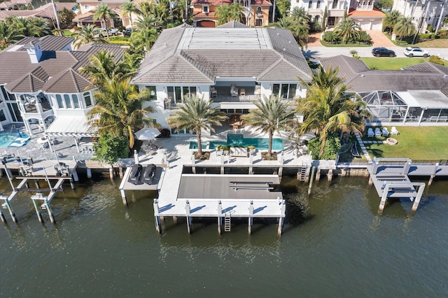 dock area with a water view, boat lift, and a residential view