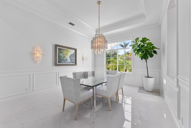 dining area featuring a decorative wall, marble finish floor, a raised ceiling, ornamental molding, and visible vents