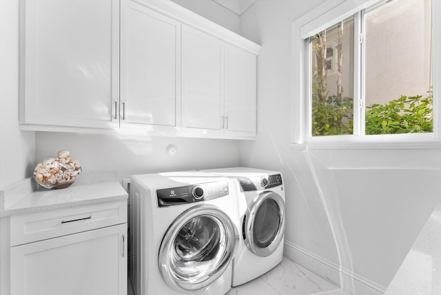 clothes washing area with cabinet space, washer and clothes dryer, and marble finish floor