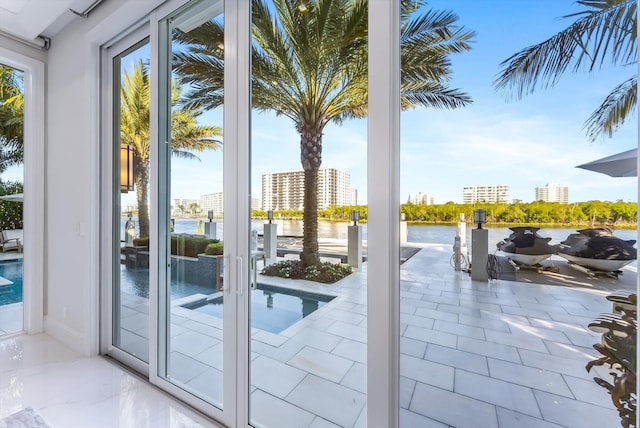 doorway to outside with a water view and a city view