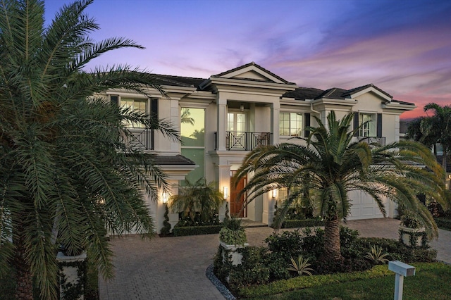 view of front of home featuring a garage, decorative driveway, and stucco siding