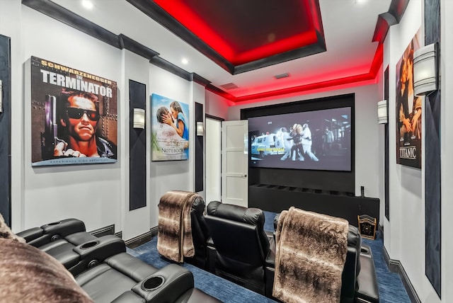 cinema room featuring carpet, a raised ceiling, visible vents, and baseboards