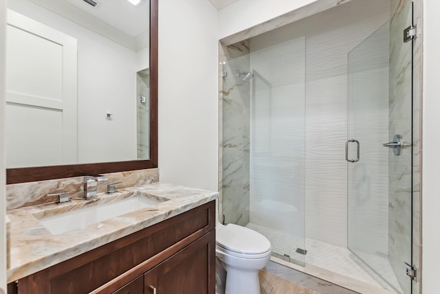 full bathroom with vanity, a shower stall, and toilet