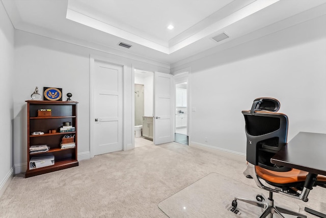 home office featuring visible vents, light carpet, baseboards, and a tray ceiling