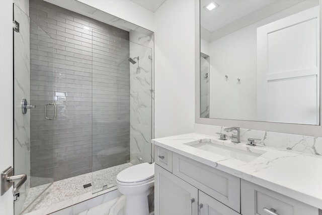 full bath with vanity, a shower stall, and toilet