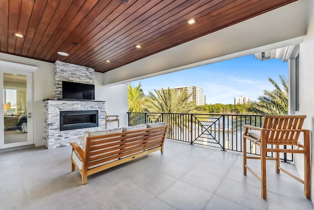 balcony featuring an outdoor living space with a fireplace and a patio