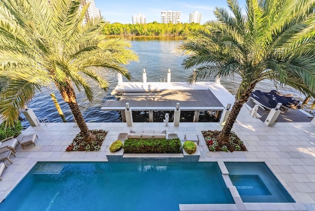 view of swimming pool featuring a pool with connected hot tub, a city view, a patio, and a water view