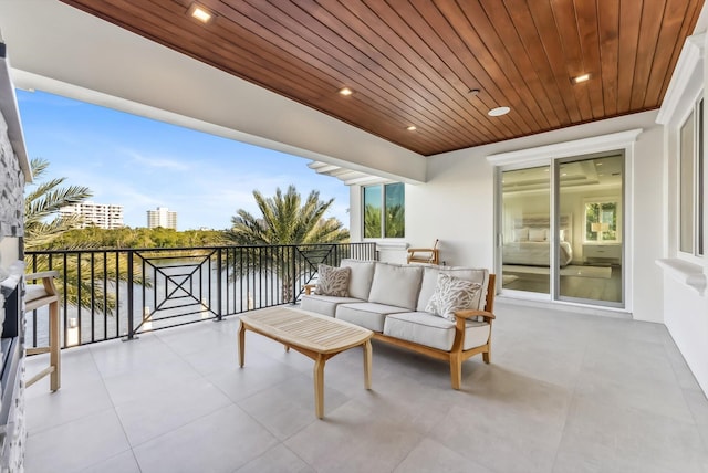 view of patio / terrace featuring a water view, a view of city, a balcony, and an outdoor hangout area