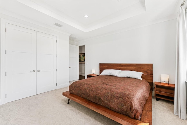 carpeted bedroom featuring visible vents, a closet, and a tray ceiling