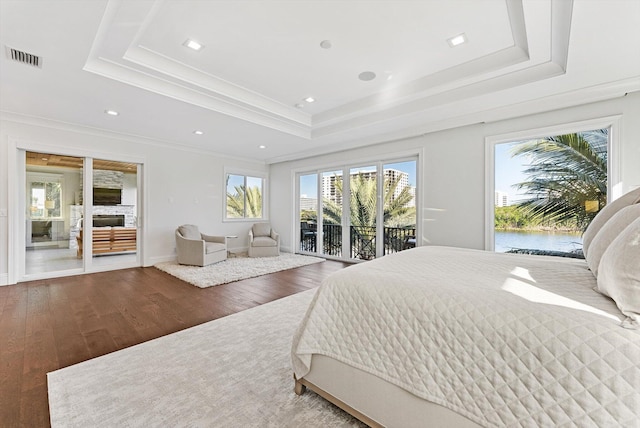 bedroom with visible vents, access to exterior, ornamental molding, wood finished floors, and a tray ceiling