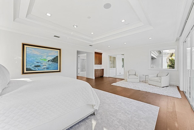 bedroom with dark wood finished floors, visible vents, a raised ceiling, ornamental molding, and recessed lighting