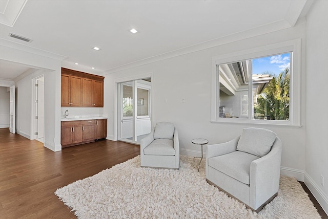 living area featuring ornamental molding, dark wood-style flooring, baseboards, and visible vents