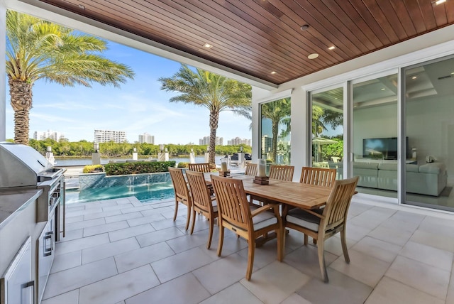 view of patio with outdoor dining space, exterior kitchen, and an outdoor pool