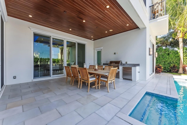 view of patio featuring exterior kitchen, an outdoor pool, grilling area, and outdoor dining area