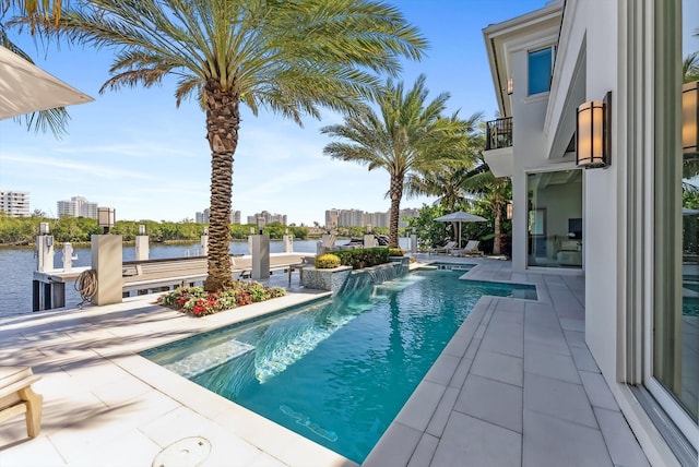 outdoor pool with a water view and a patio area