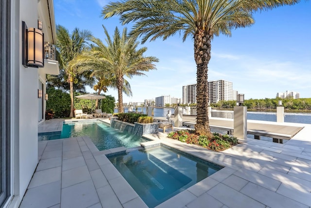 view of swimming pool with a water view, a patio area, a city view, and a pool with connected hot tub