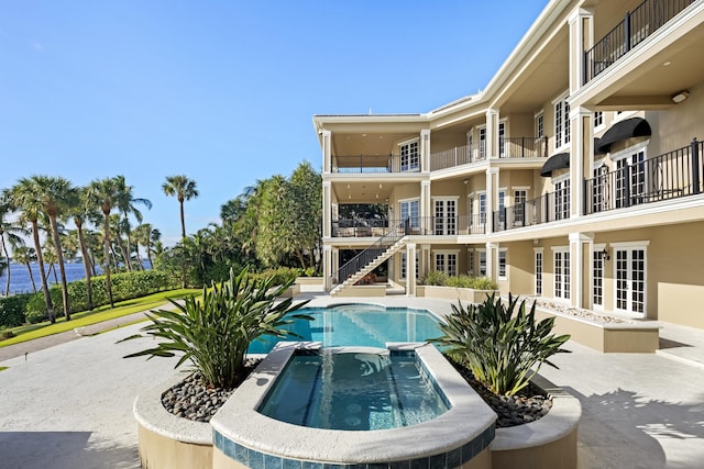 view of swimming pool featuring a patio and a pool with connected hot tub