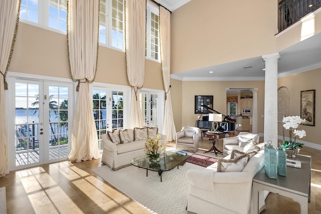 living area featuring ornate columns, a high ceiling, crown molding, and french doors