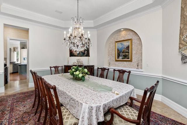 tiled dining space featuring baseboards, a raised ceiling, and crown molding