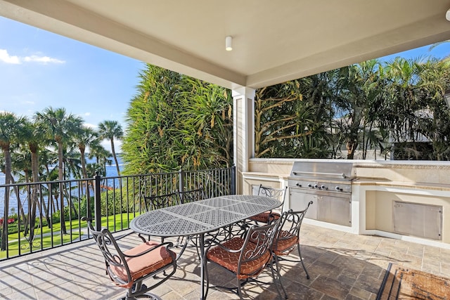 view of patio featuring outdoor dining area, an outdoor kitchen, and a grill