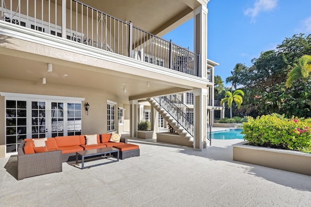 view of patio / terrace featuring an outdoor pool, an outdoor living space, and stairs