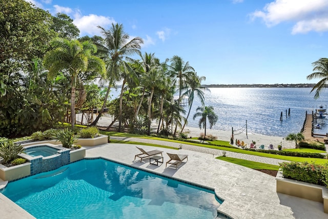 view of swimming pool featuring a water view, a patio area, and a pool with connected hot tub