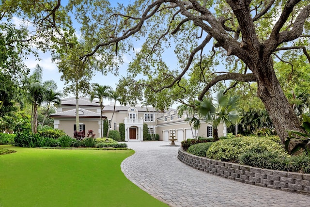 mediterranean / spanish house with decorative driveway, a balcony, and stucco siding