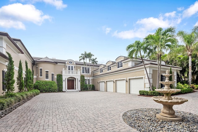 view of front facade featuring a garage, decorative driveway, and stucco siding