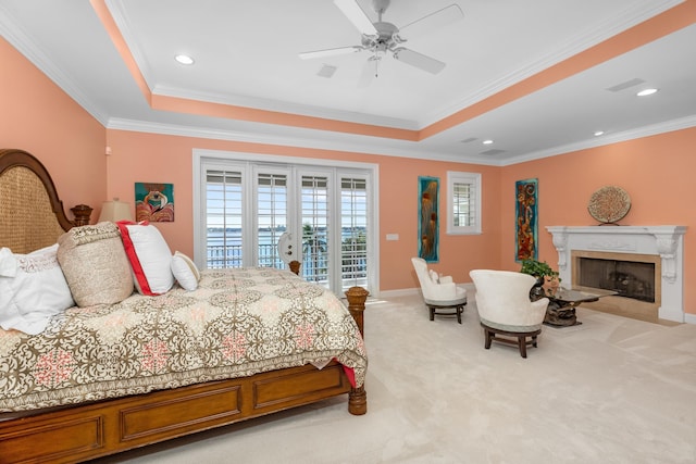 bedroom with light colored carpet, a premium fireplace, ornamental molding, access to outside, and a tray ceiling