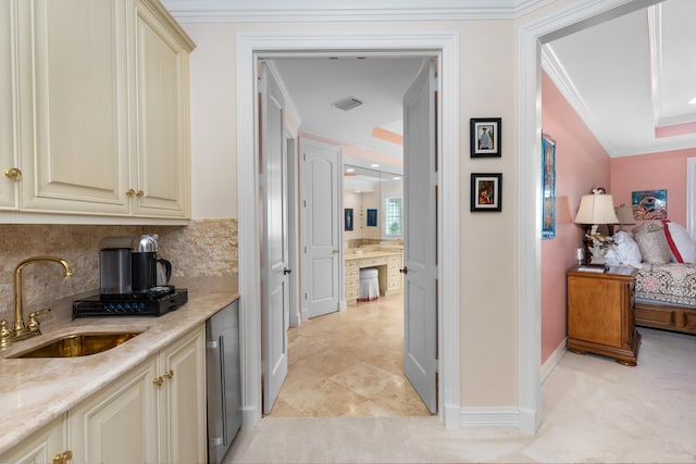 corridor with light tile patterned flooring, a sink, visible vents, baseboards, and ornamental molding