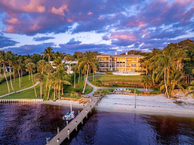 view of dock featuring a water view and a yard