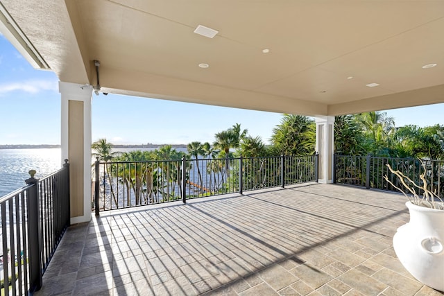 view of patio / terrace with a water view and a balcony