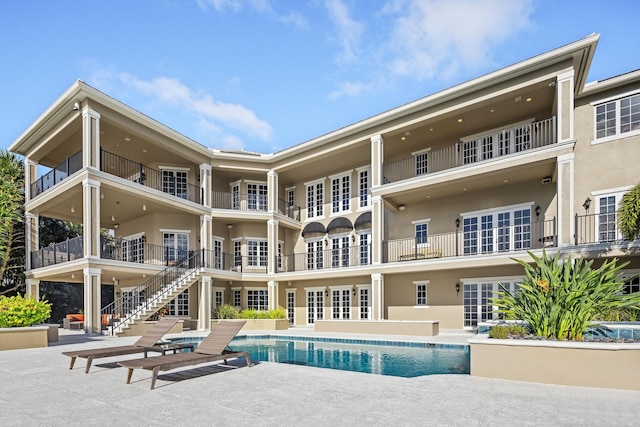 pool with stairway and a patio