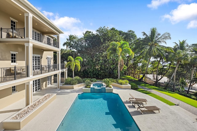 view of pool featuring a pool with connected hot tub and a patio