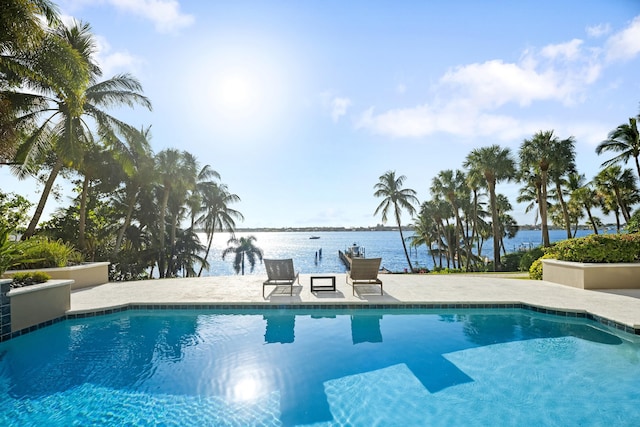 outdoor pool featuring a water view and a patio area