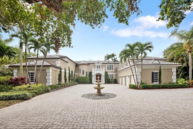 view of front of property featuring a garage, curved driveway, and stucco siding