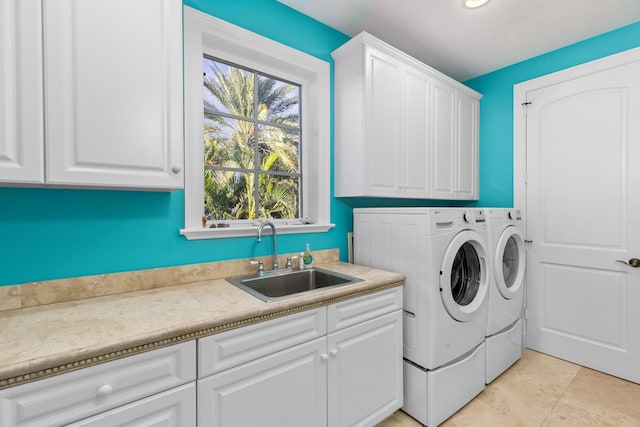 clothes washing area featuring cabinet space, a sink, washing machine and clothes dryer, and light tile patterned floors