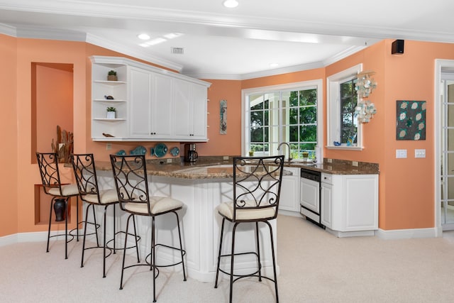 kitchen with a breakfast bar, light carpet, a peninsula, and open shelves