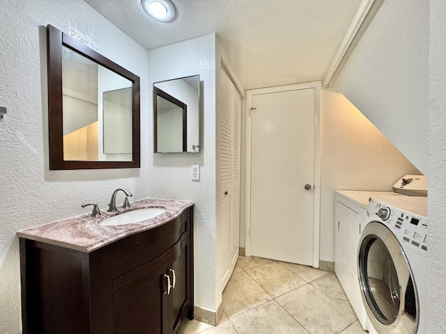 laundry room featuring laundry area, washer and clothes dryer, a textured wall, a textured ceiling, and a sink