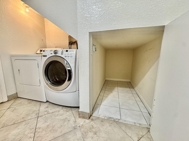 laundry area with washing machine and dryer, laundry area, and baseboards